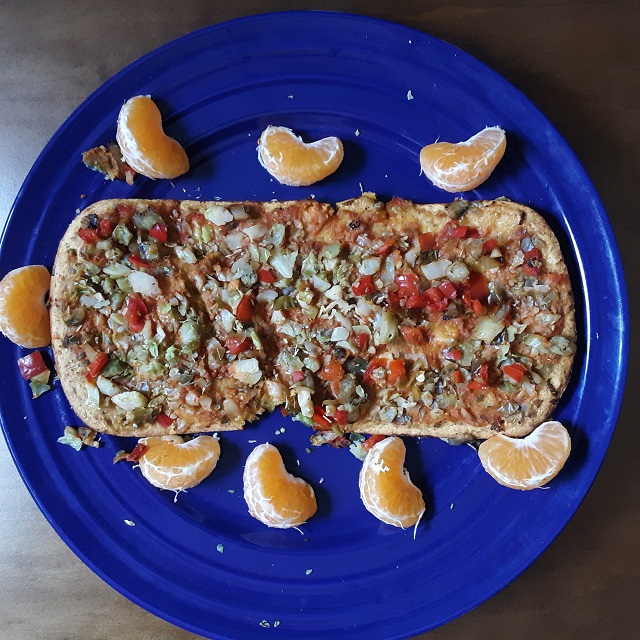 This image has an empty alt attribute; its file name is Flatbread-on-plate-with-tangerine-slices-from-above.jpg