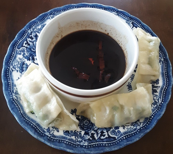 Gyoza on Plate Surrounding Dipping Sauce in Bowl