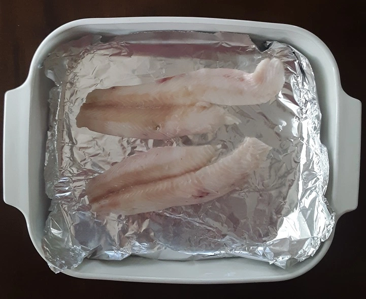 Rockfish fillets in baking dish with aluminum foil