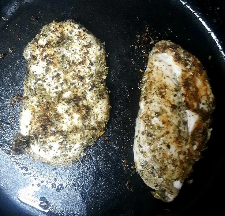 Two boneless skinless chicken breasts in skillet