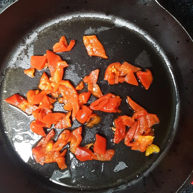 Sliced Roasted Red Peppers Sauteing in Skillet