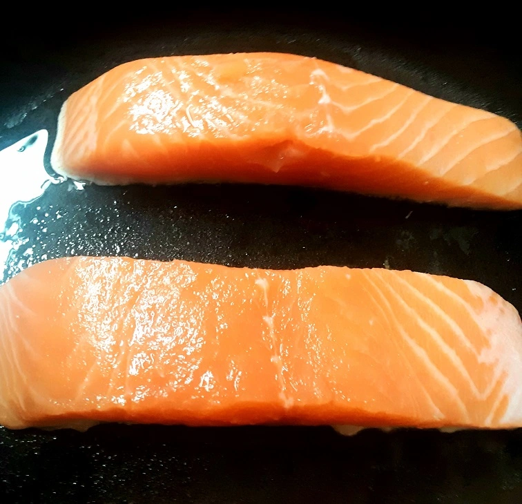Two Salmon Fillets in Skillet Skin-Sides Down