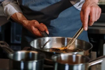 Chef Cooking Fish in Stainless Steel Nonstick Pan